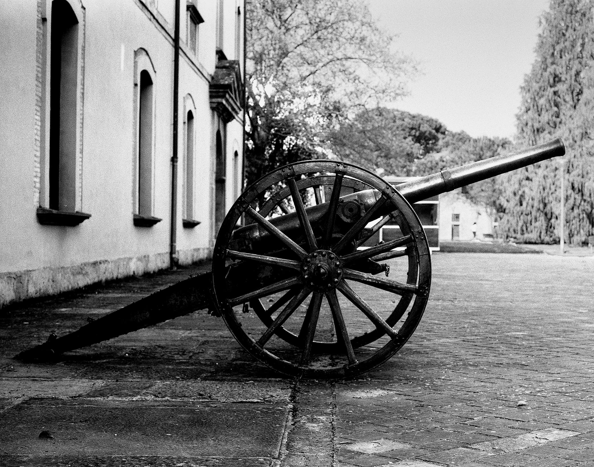 Historic cannon with wooden wheels under stone archway in Spanish fortress courtyard