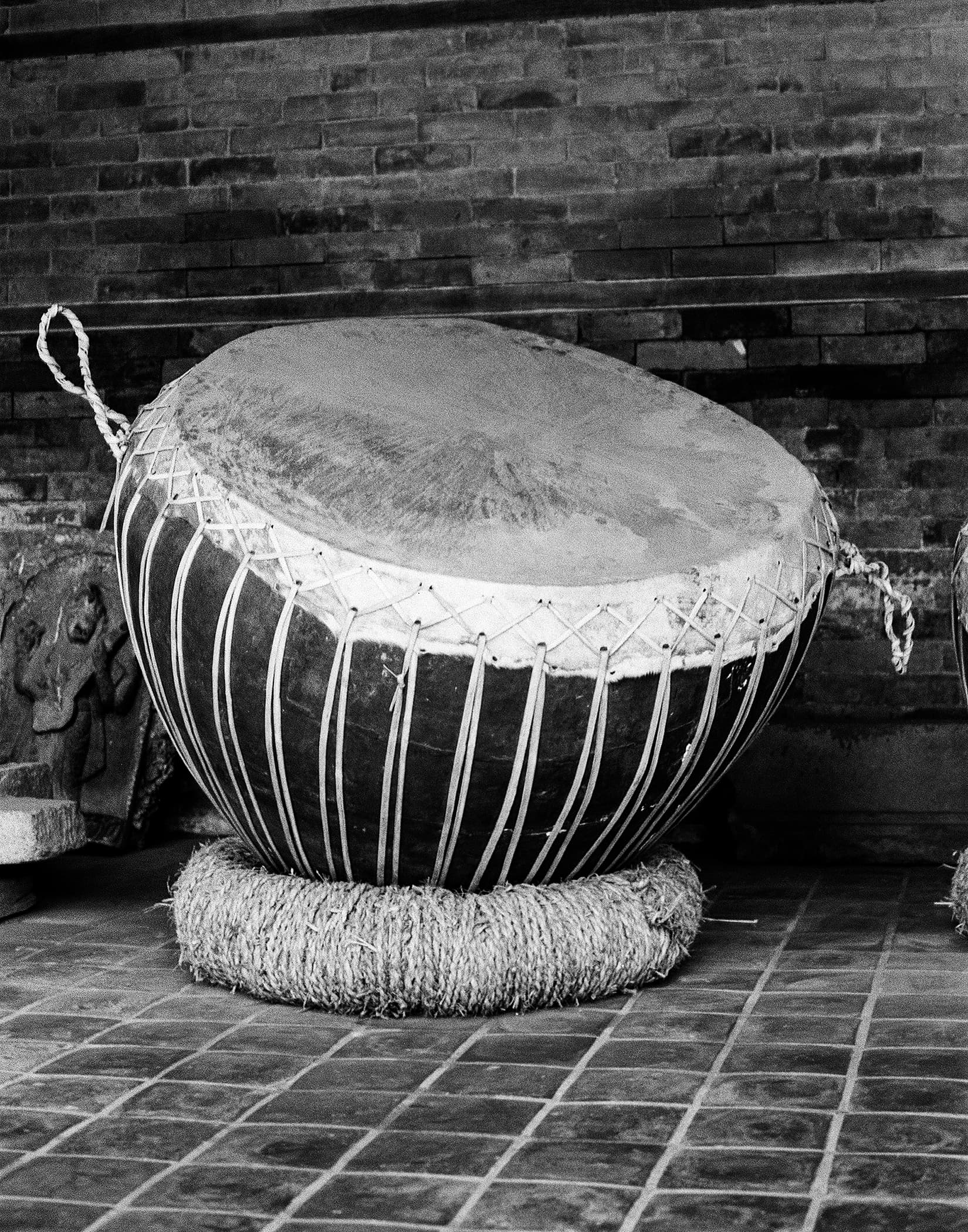 Large laced drum resting on a woven straw ring