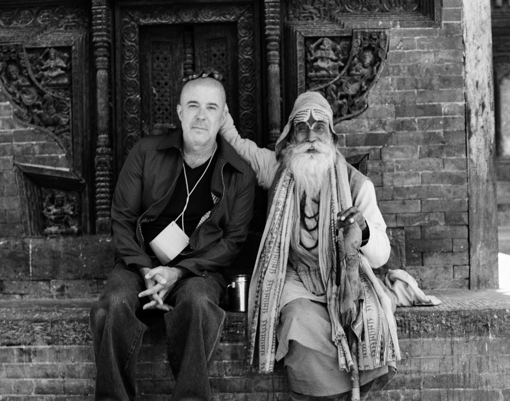 Portrait of a traveler seated beside a bearded holy man