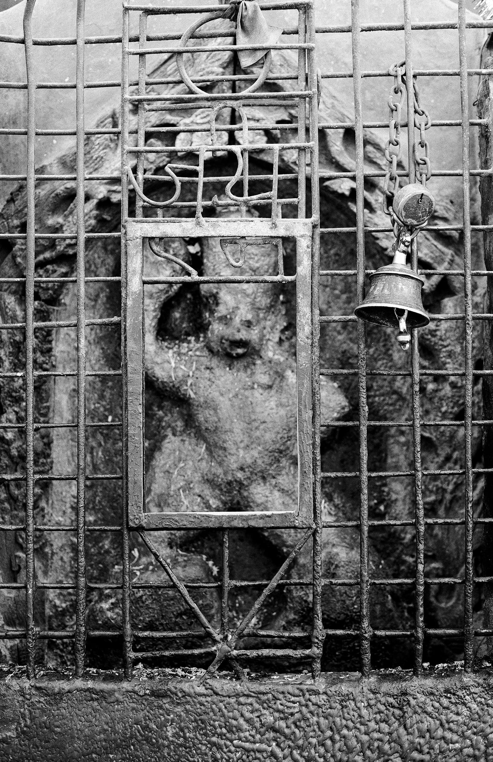 Small bell hanging before a caged animal statue