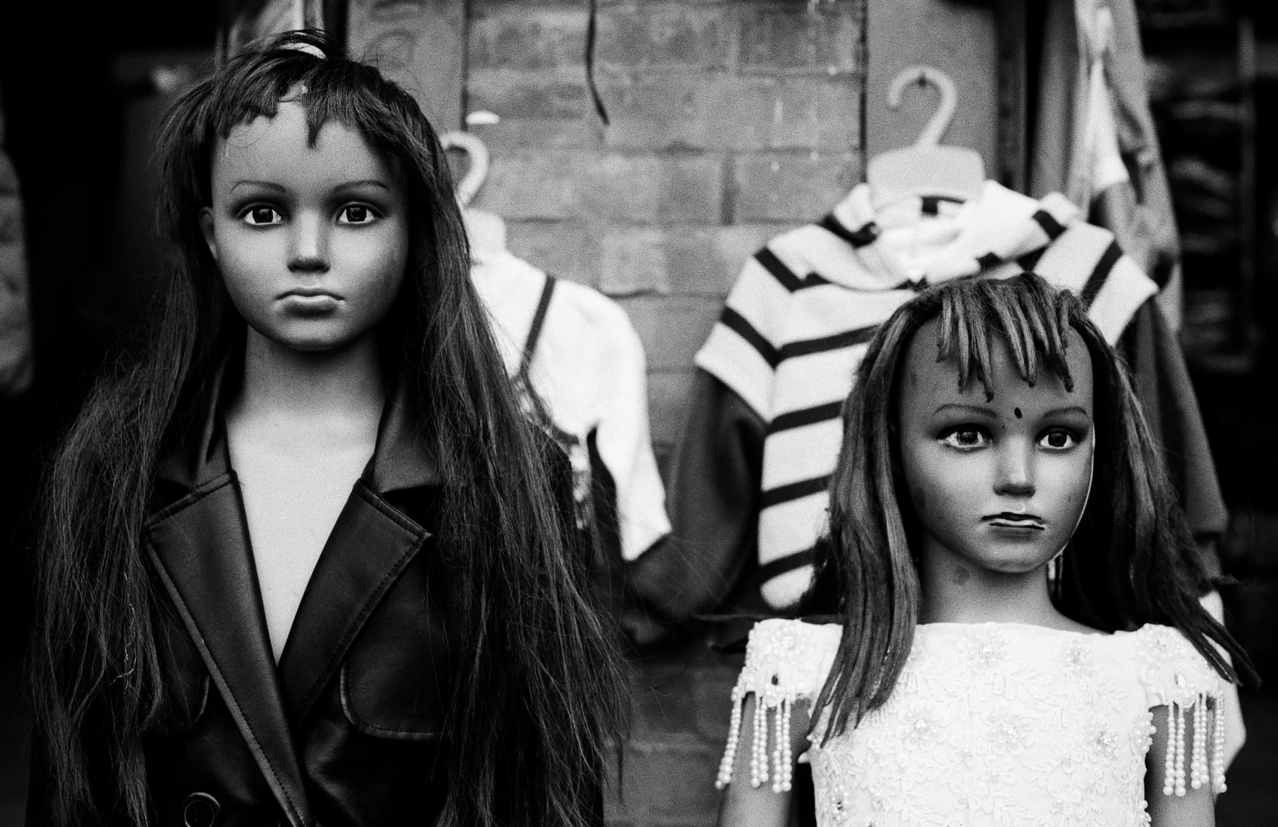 Two carved dolls in a market display
