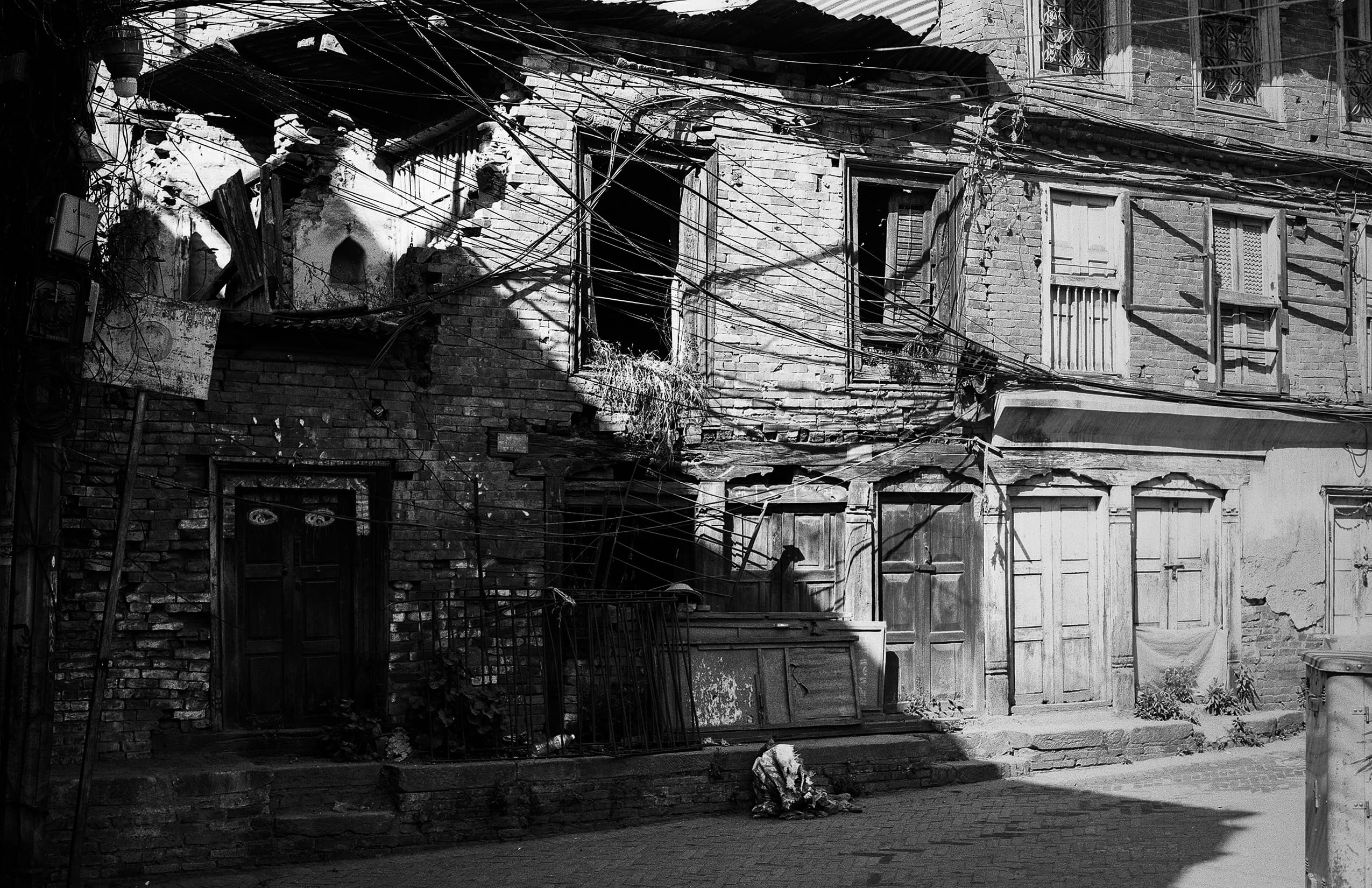 Weathered brick courtyard with tangled overhead wires