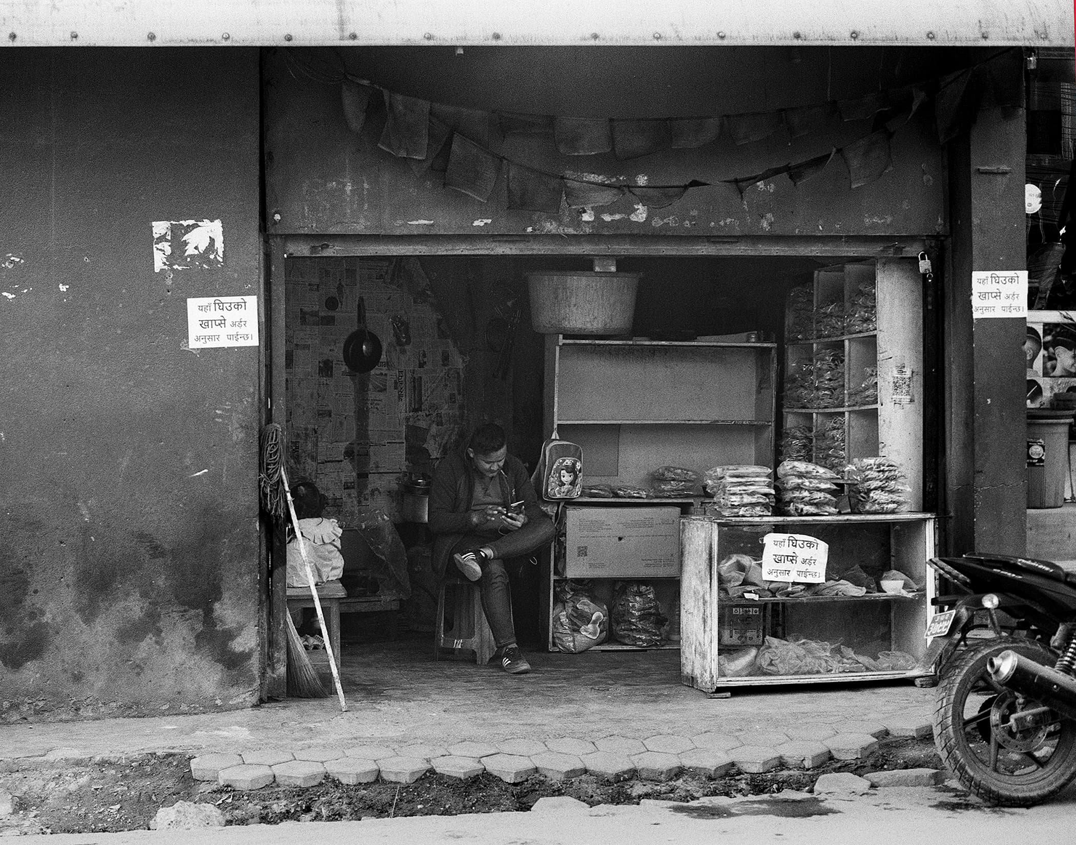 Small neighborhood shopfront with packaged goods and Nepali signs