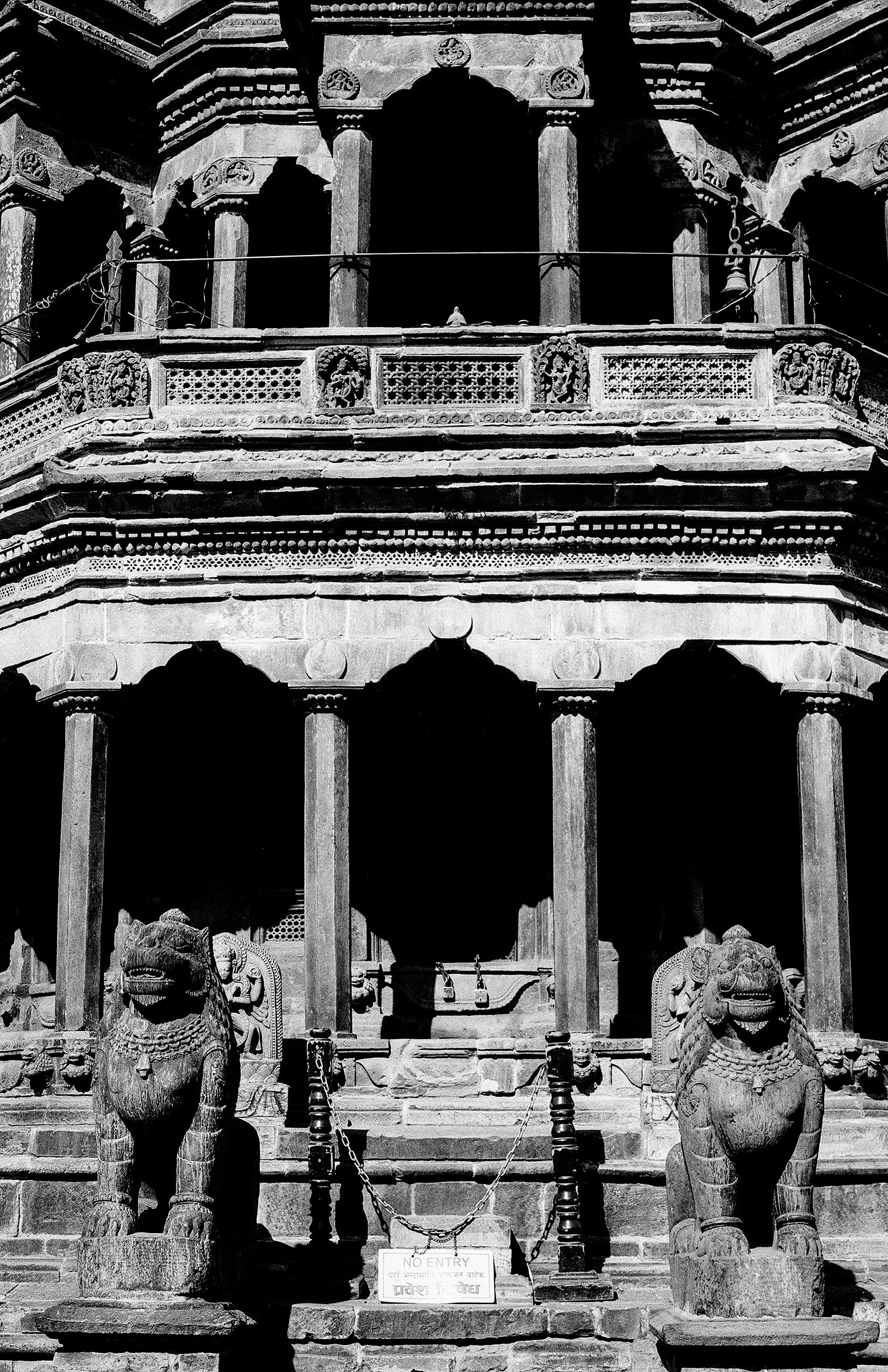 Highly carved temple facade guarded by two stone lions