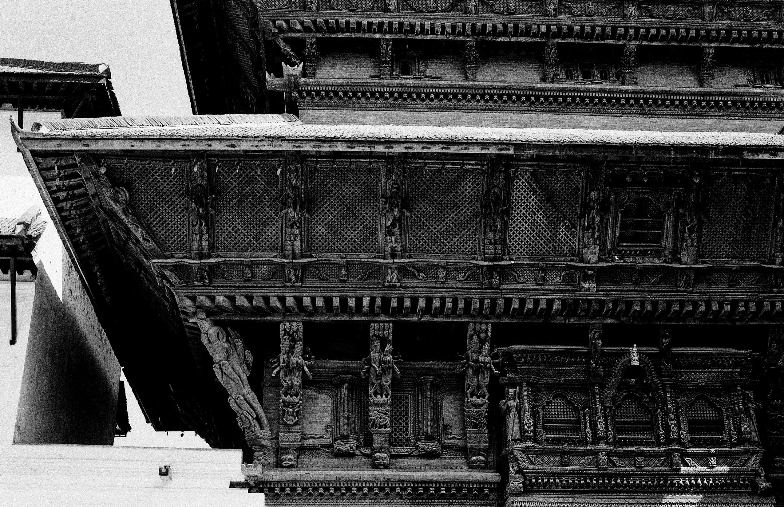 Detailed carved wooden temple facade with lattice windows
