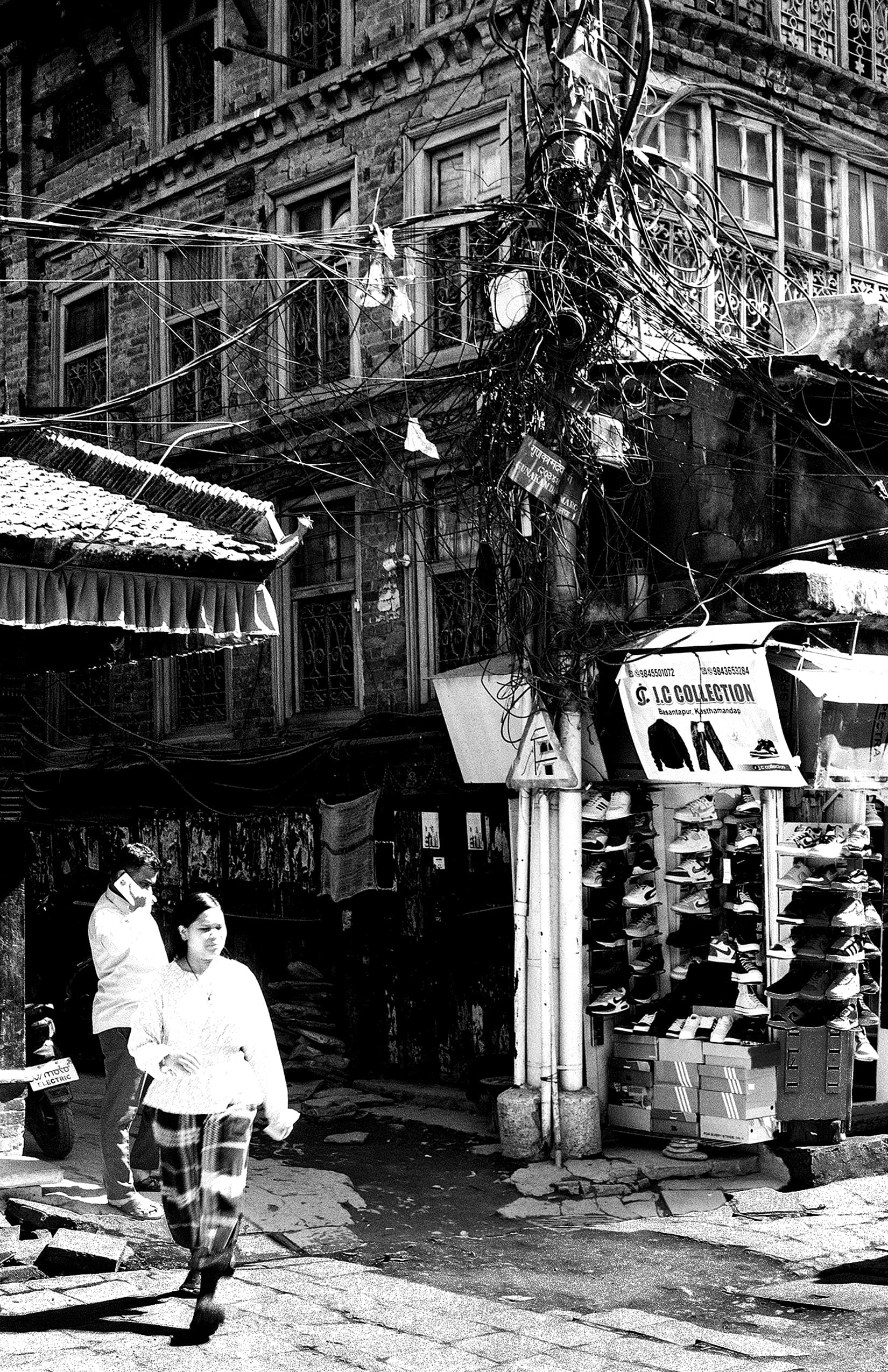 Market street with tangled utility wires and a shoe shop
