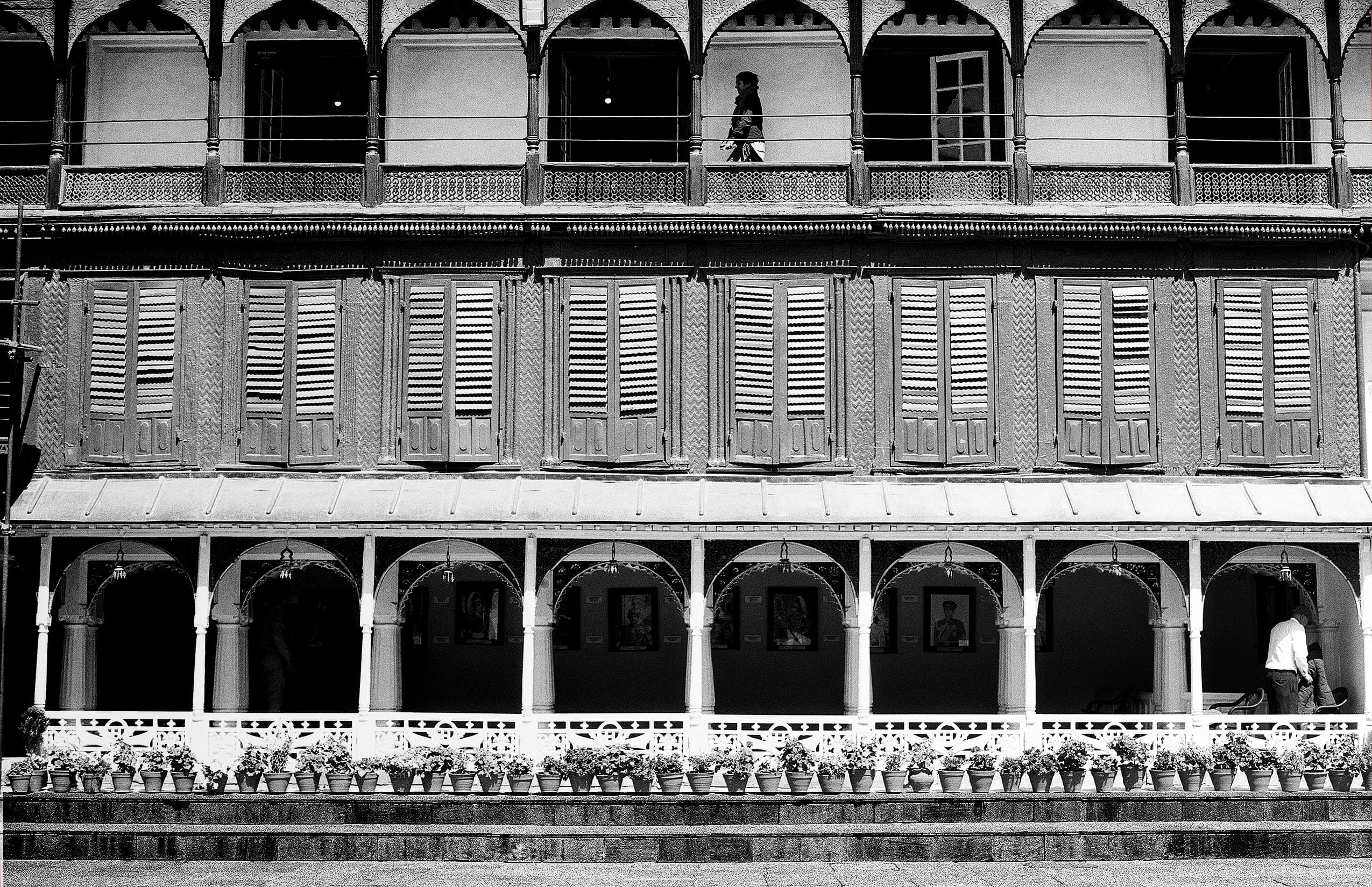 Open museum courtyard with repeating arches and potted plants
