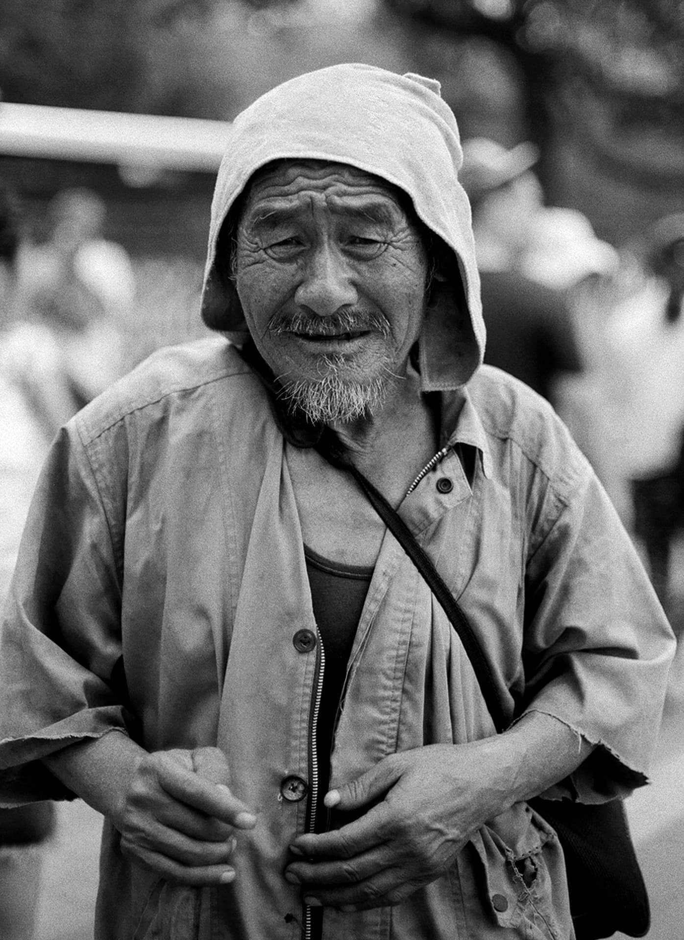 Portrait of elderly man wearing light colored jacket and white head covering