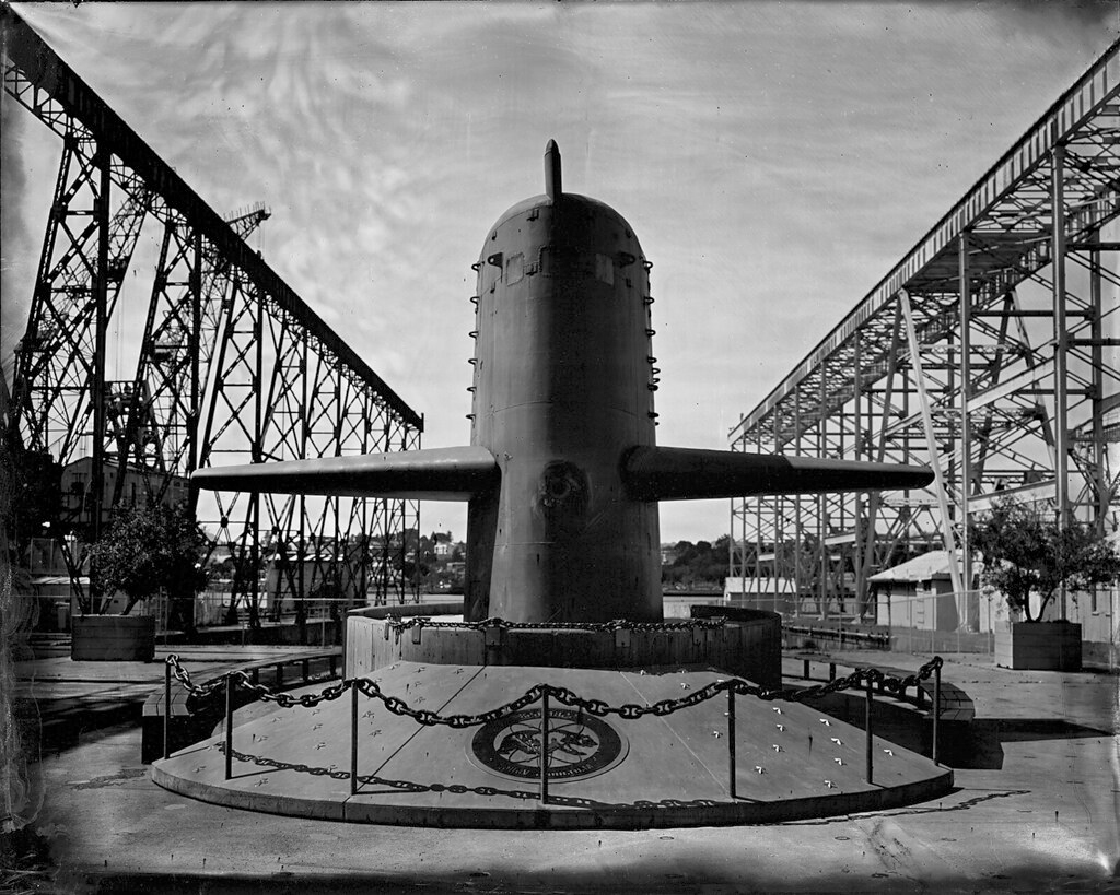Submarine hull on display surrounded by industrial steel framework and docking infrastructure