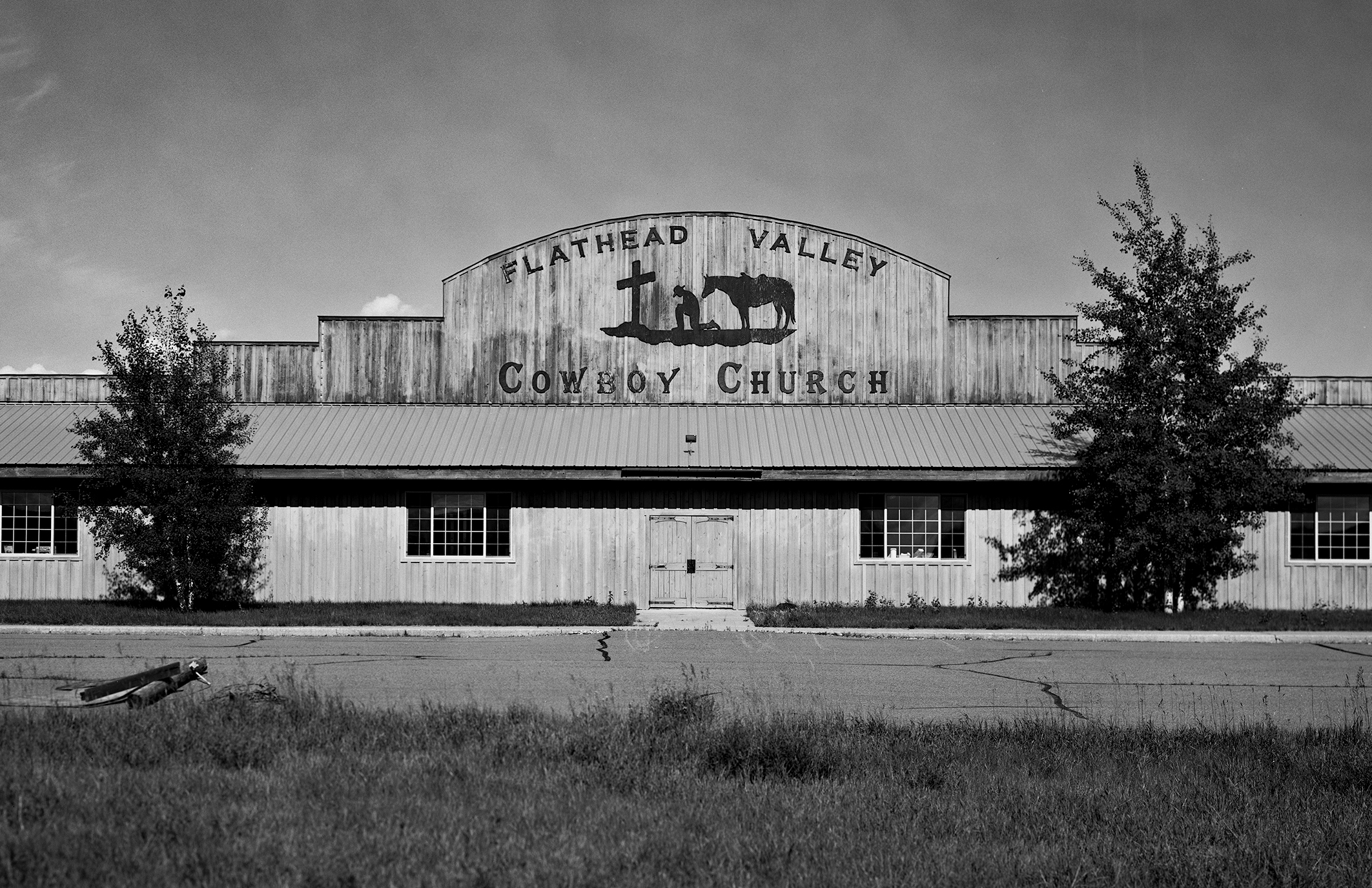 Flathead Valley Cowboy Church rustic wooden building with praying cowboy and horse silhouette